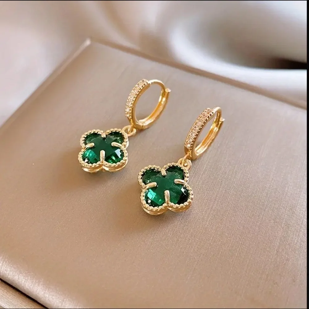 clover-shaped dangle earrings featuring green stones and gold plating with paved